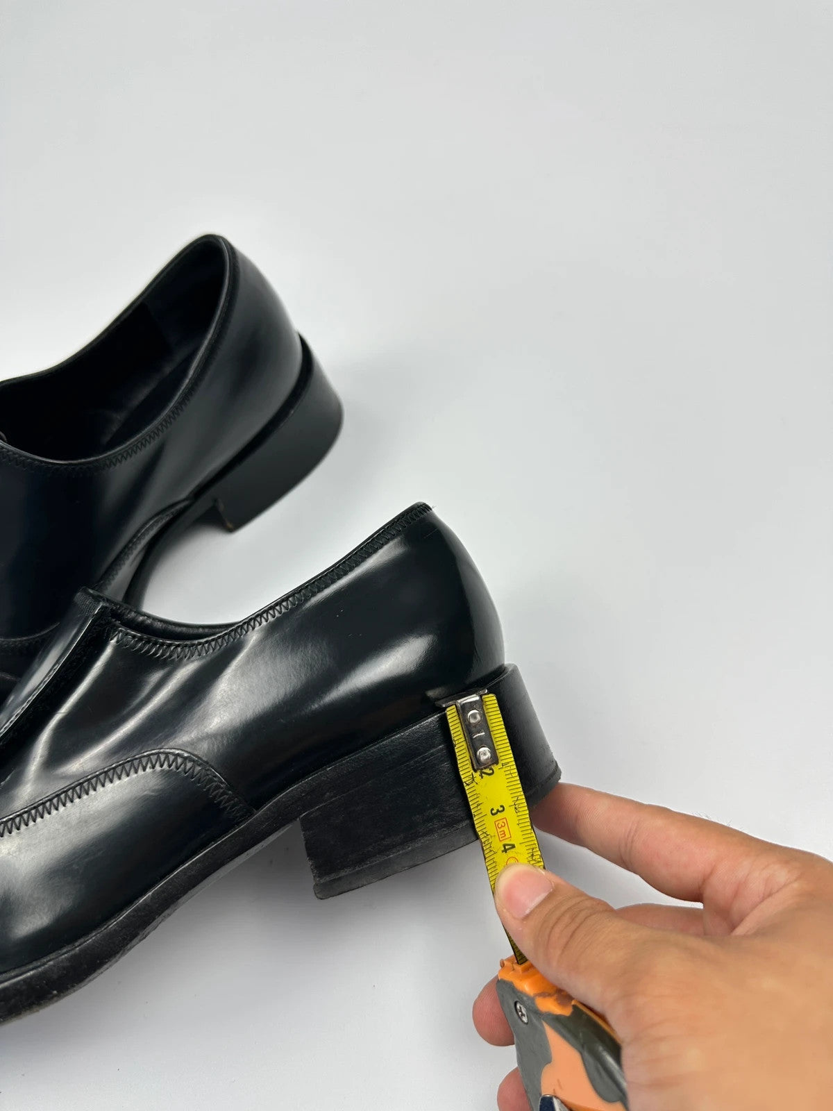 Prada black vernis loafers with pointy toe and subtle logo detailing.