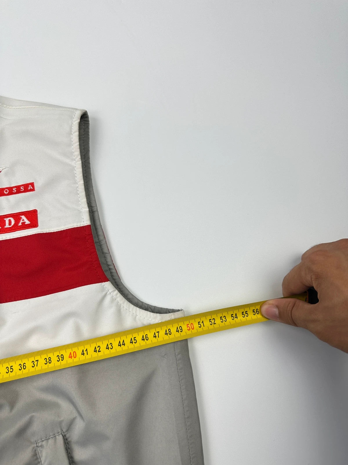 Prada red racing vest with white Luna Rossa logo and minimalist design.