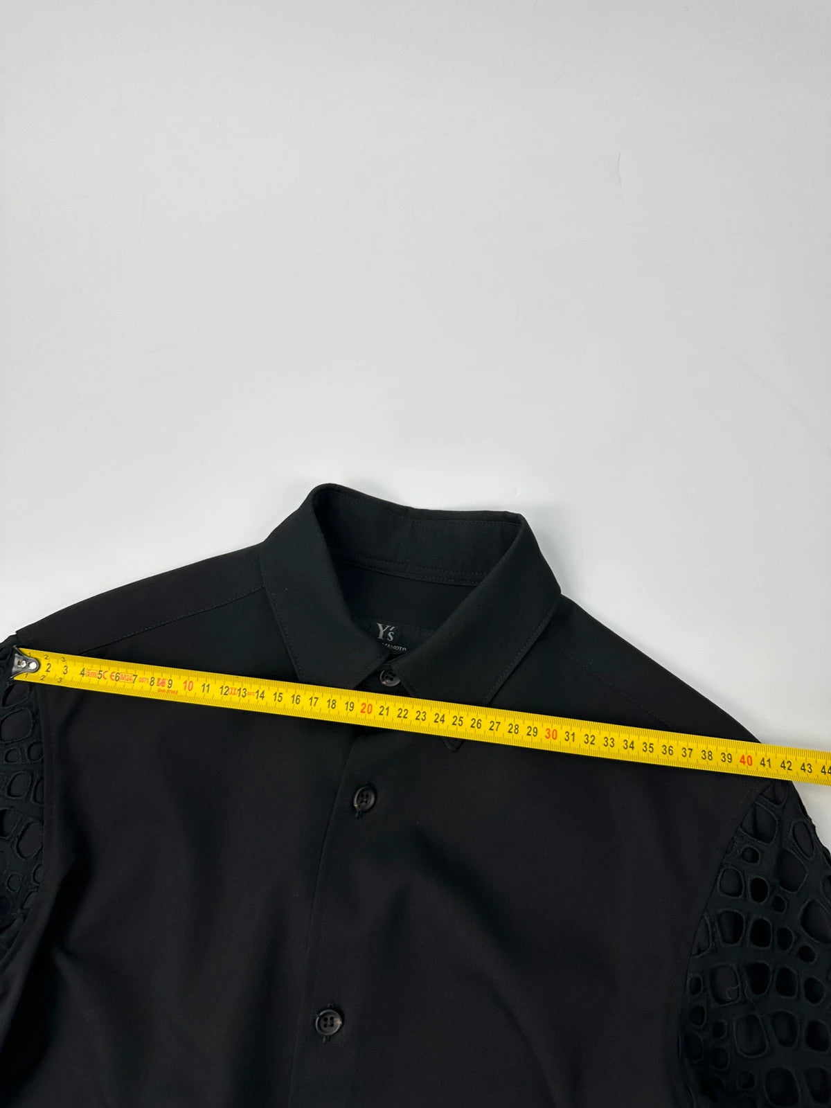 Y's by Yohji Yamamoto black shirt with mesh sleeves and subtle logo details.