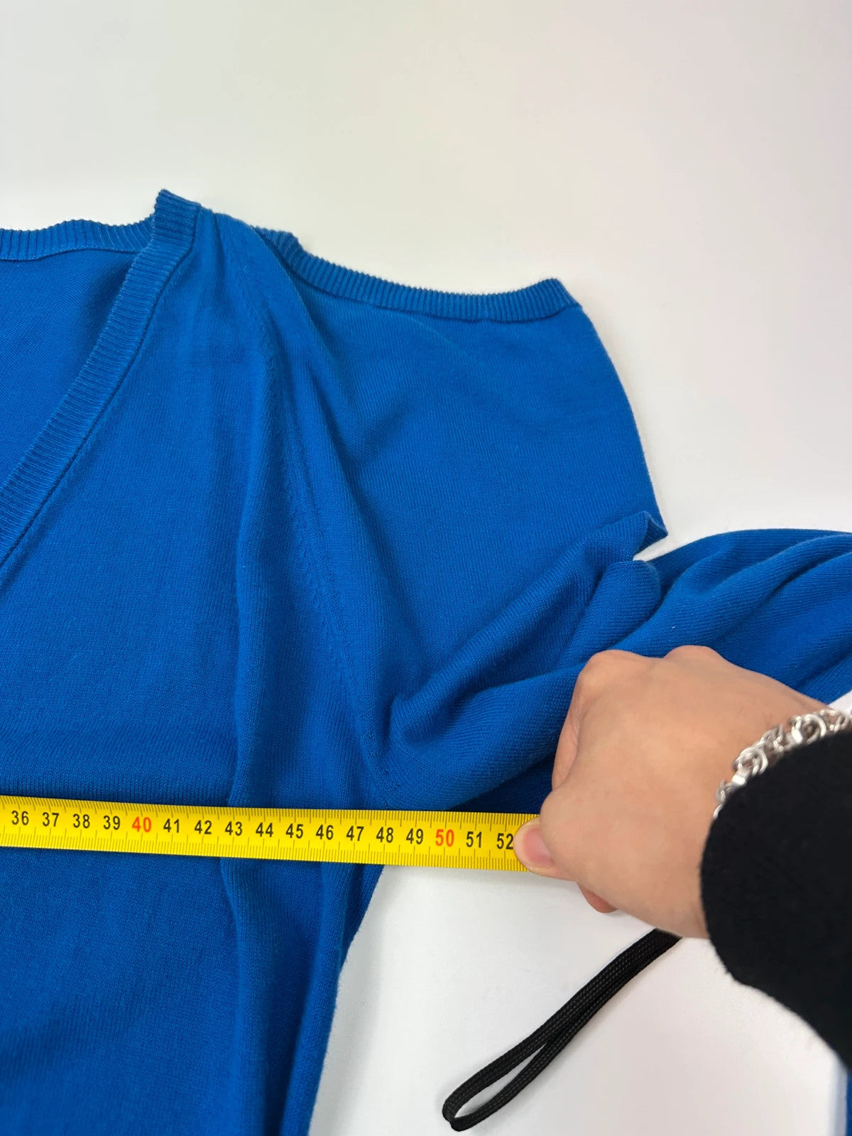 Maison Margiela electric blue cardigan with shoulder holes, minimalist design, soft knit material.