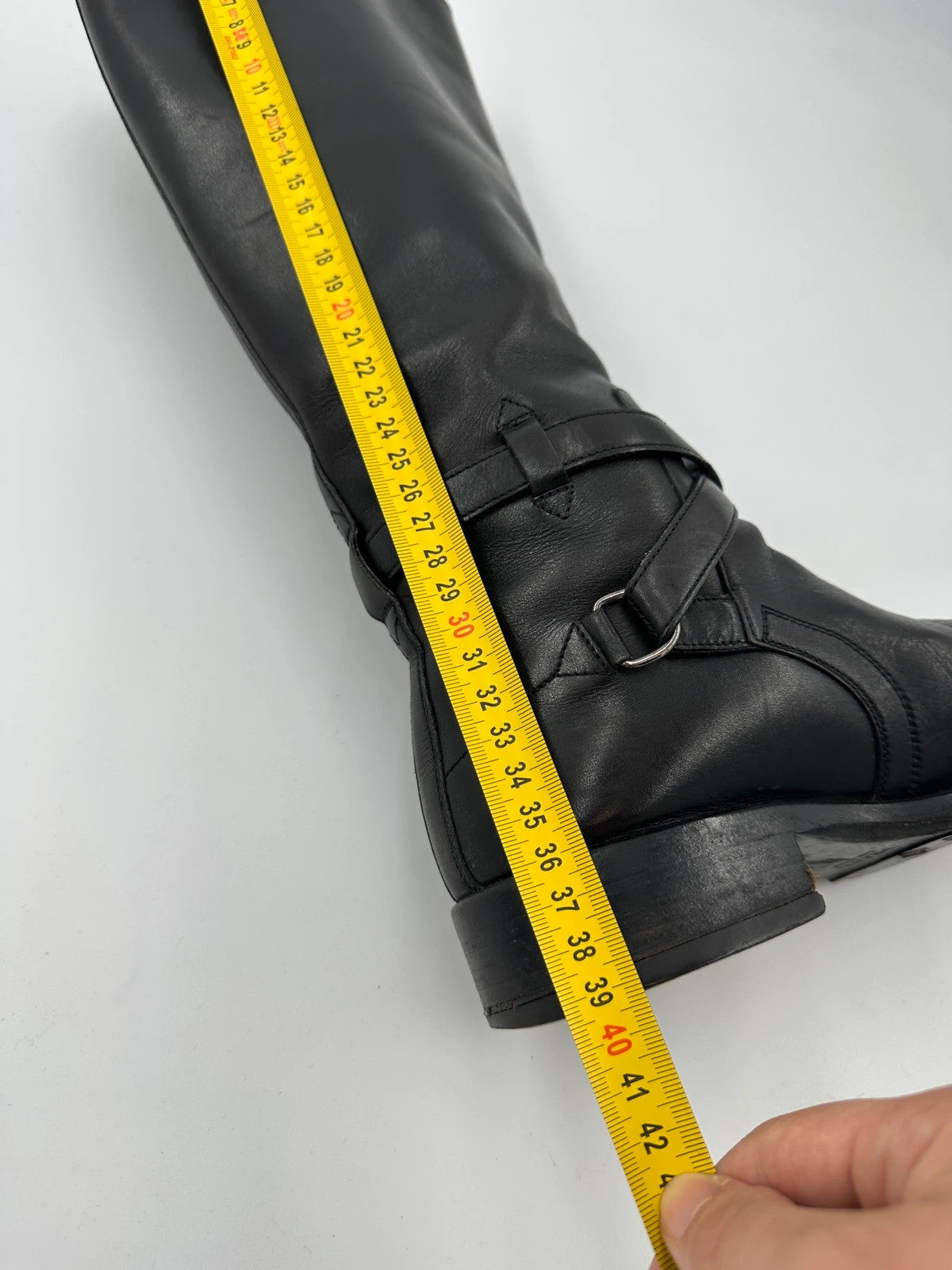 Prada black leather knee-high boots with high belt detail and minimalist design.