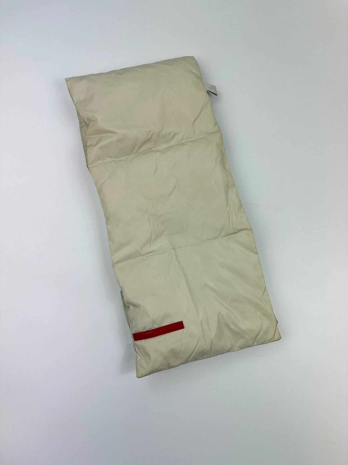 Prada beige puffer scarf with cream accents and magnetic closure, featuring signature logo.