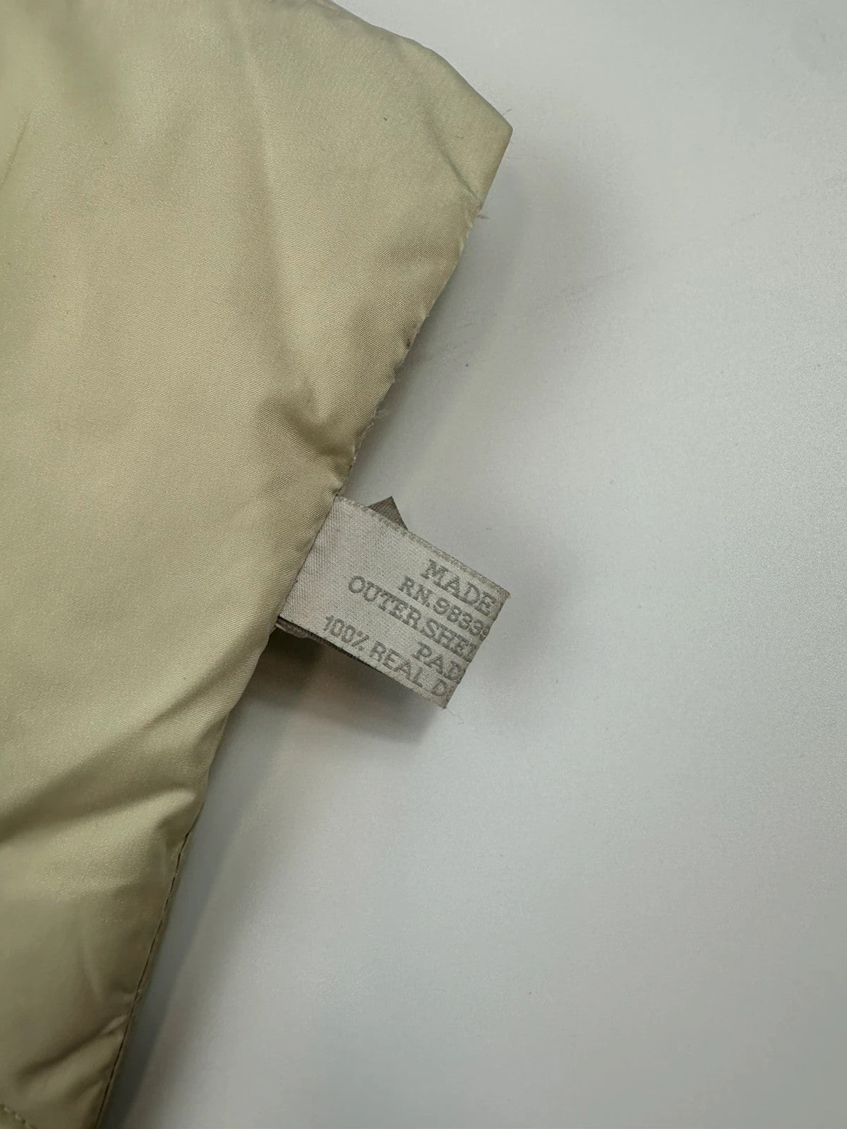 Prada beige puffer scarf with cream accents and magnetic closure, featuring signature logo.