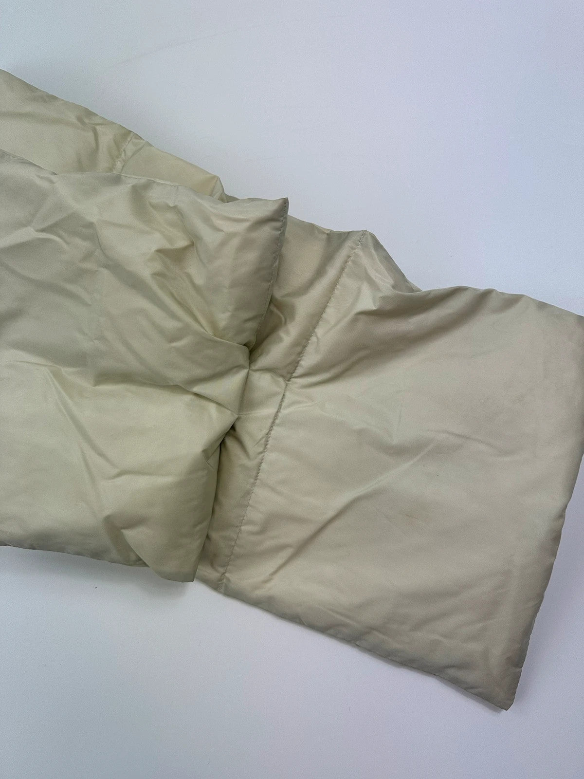 Prada beige puffer scarf with cream accents and magnetic closure, featuring signature logo.