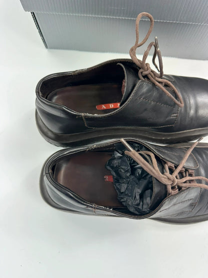 Prada black and brown leather loafer with Vibram puddle sole and moccasin design.