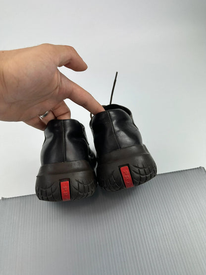 Prada black and brown leather loafer with Vibram puddle sole and moccasin design.