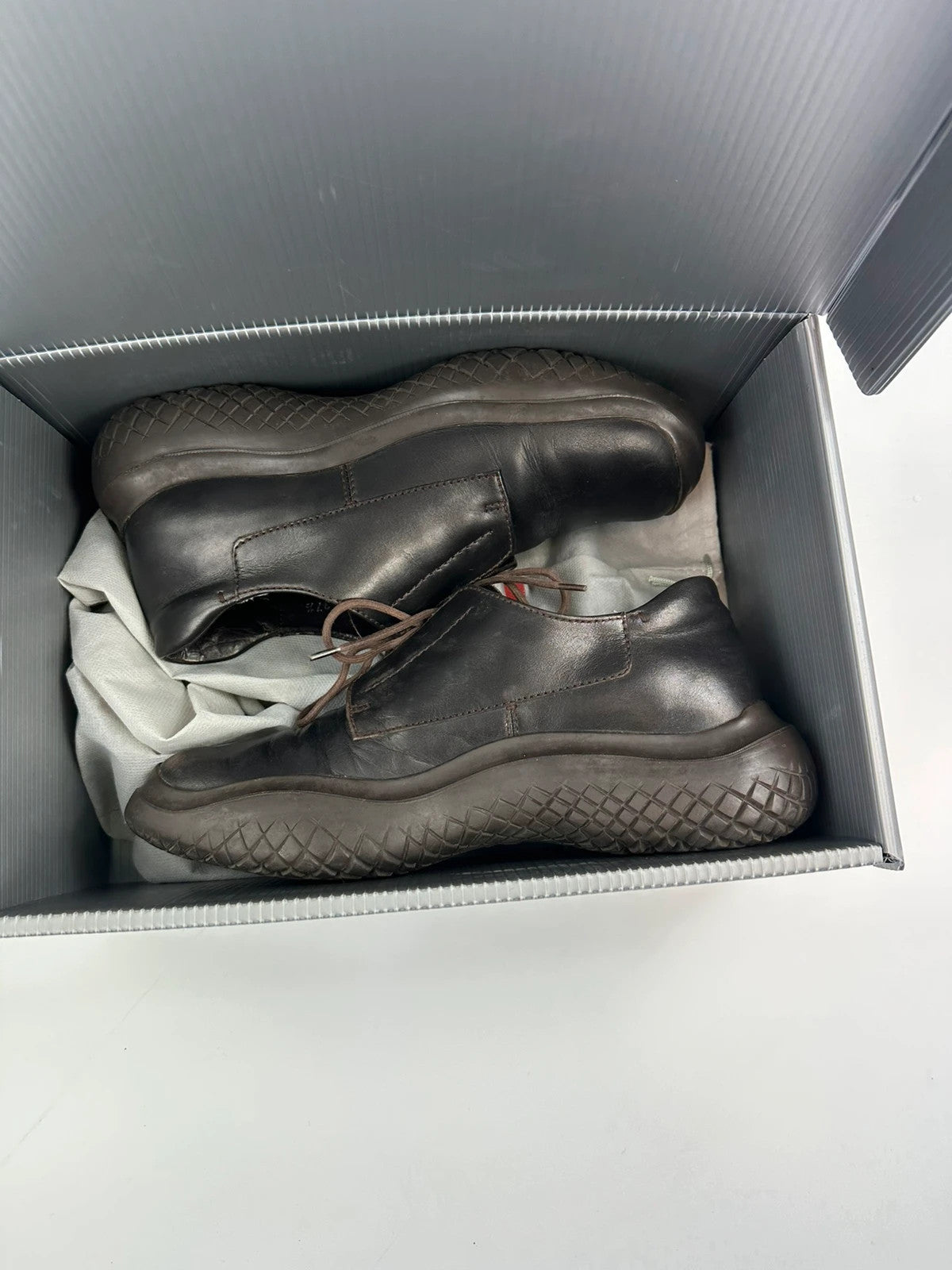Prada black and brown leather loafer with Vibram puddle sole and moccasin design.