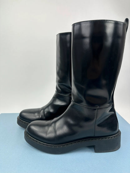 Prada black knee-high boots in patent leather with logo detail and elegant design.