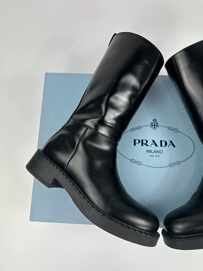 Prada black knee-high boots in patent leather with logo detail and elegant design.