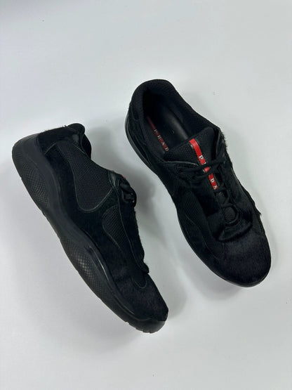 Prada black trainers with fur accents and mesh detailing, includes authenticity card.