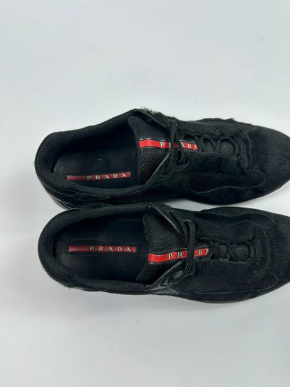 Prada black trainers with fur accents and mesh detailing, includes authenticity card.
