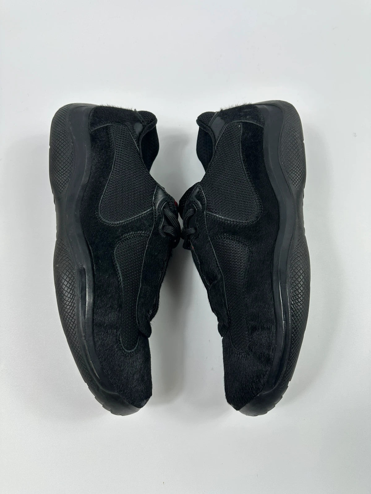 Prada black trainers with fur accents and mesh detailing, includes authenticity card.