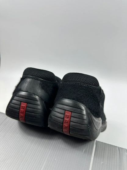 Prada black trainers with fur accents and mesh detailing, includes authenticity card.
