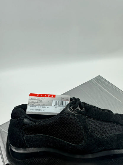 Prada black trainers with fur accents and mesh detailing, includes authenticity card.