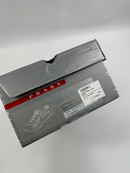 Prada black trainers with fur accents and mesh detailing, includes authenticity card.