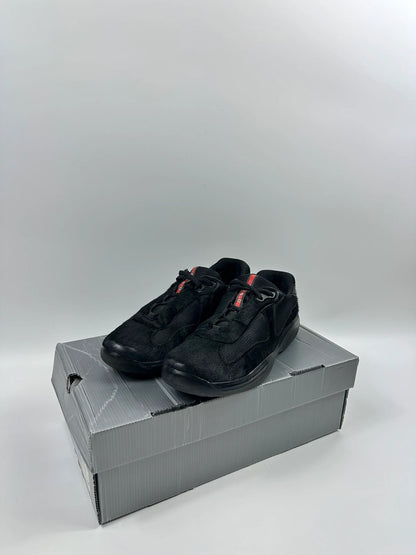 Prada black trainers with fur accents and mesh detailing, includes authenticity card.