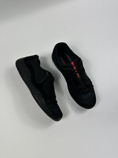 Prada black trainers with fur accents and mesh detailing, includes authenticity card.