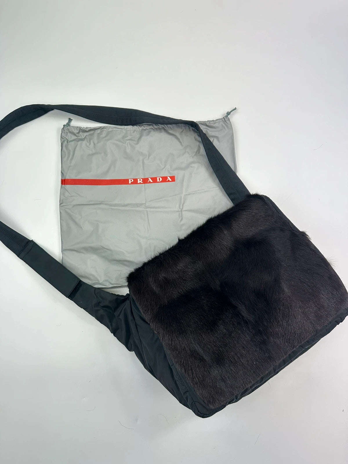 Prada black nylon crossbody bag with fur accents and linearossa logo.