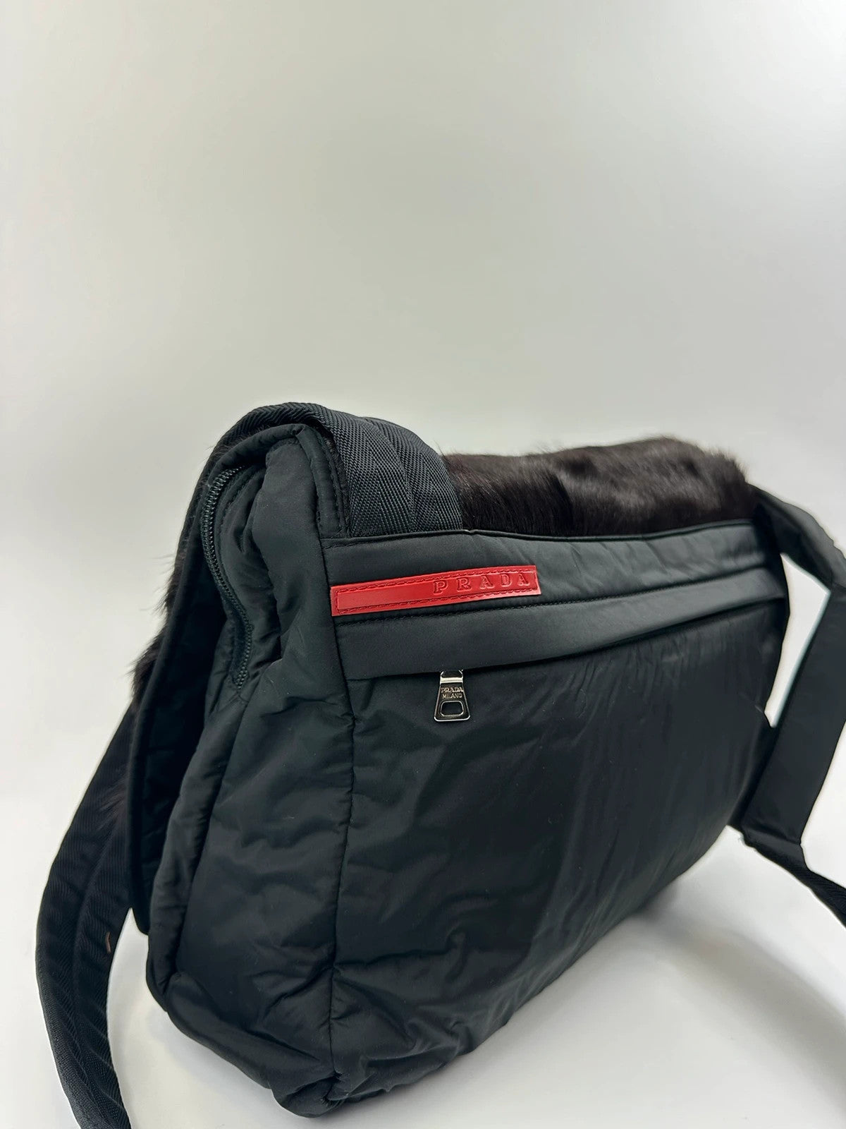 Prada black nylon crossbody bag with fur accents and linearossa logo.