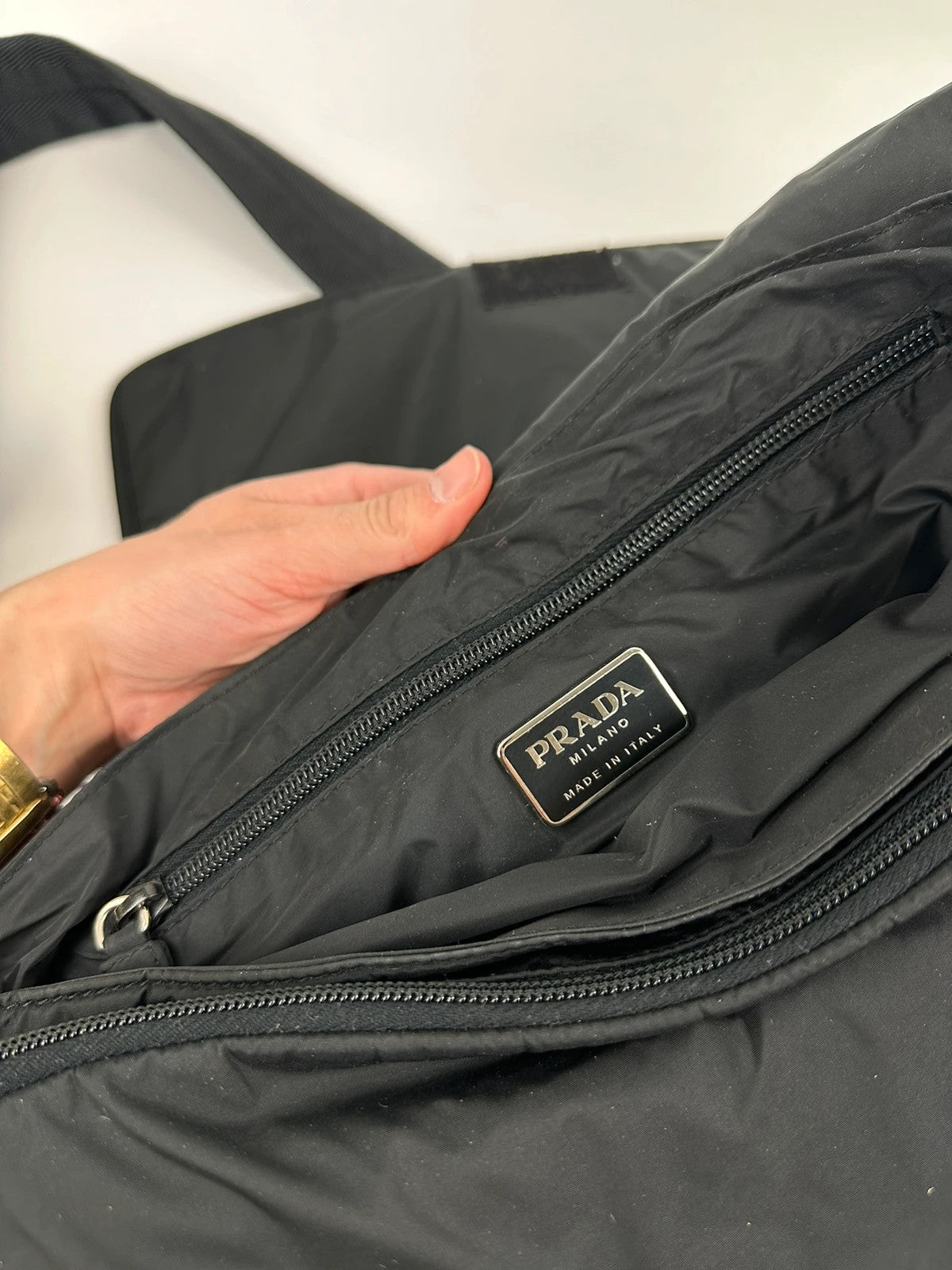 Prada black nylon crossbody bag with fur accents and linearossa logo.