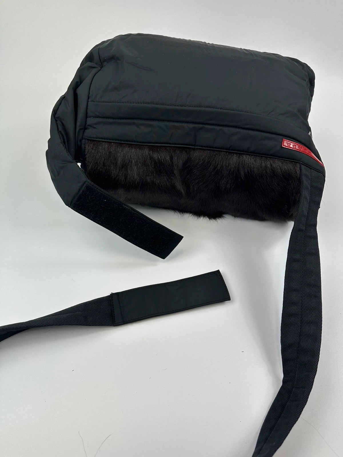 Prada black nylon crossbody bag with fur accents and linearossa logo.