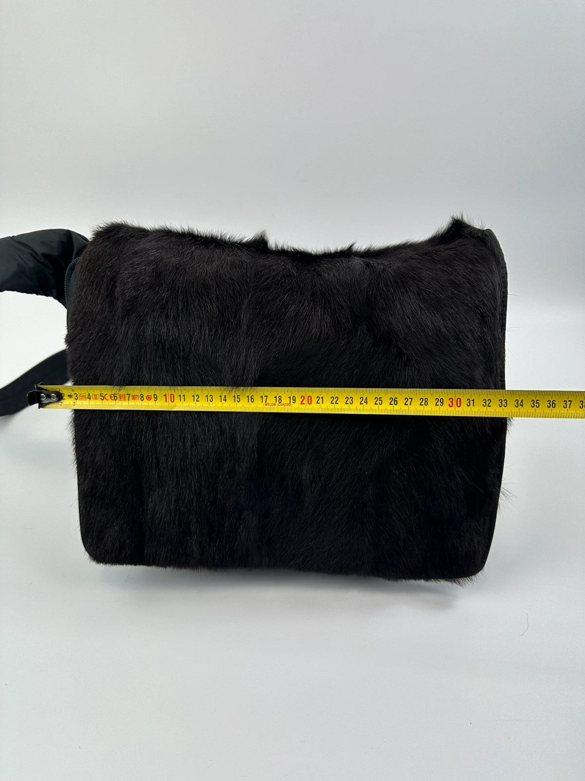 Prada black nylon crossbody bag with fur accents and linearossa logo.