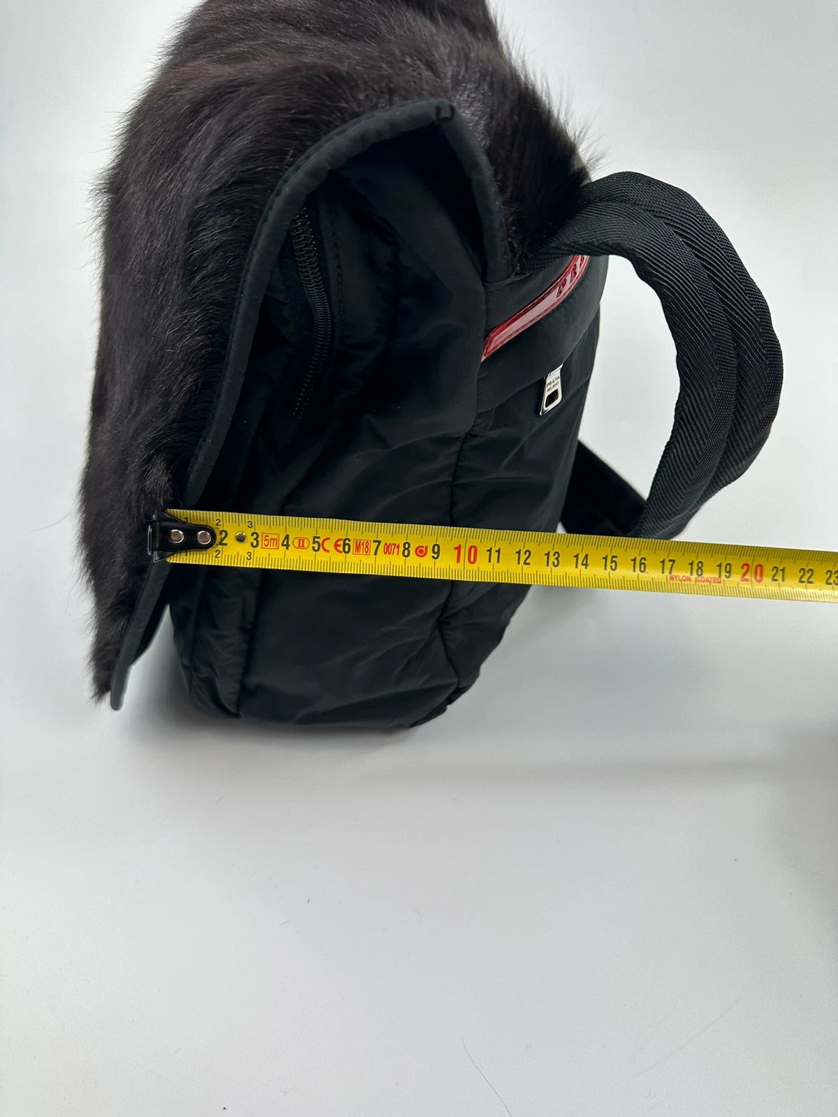 Prada black nylon crossbody bag with fur accents and linearossa logo.