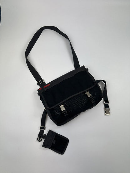 Prada black and grey mesh crossbody waist bag with logo and dual compartment design.