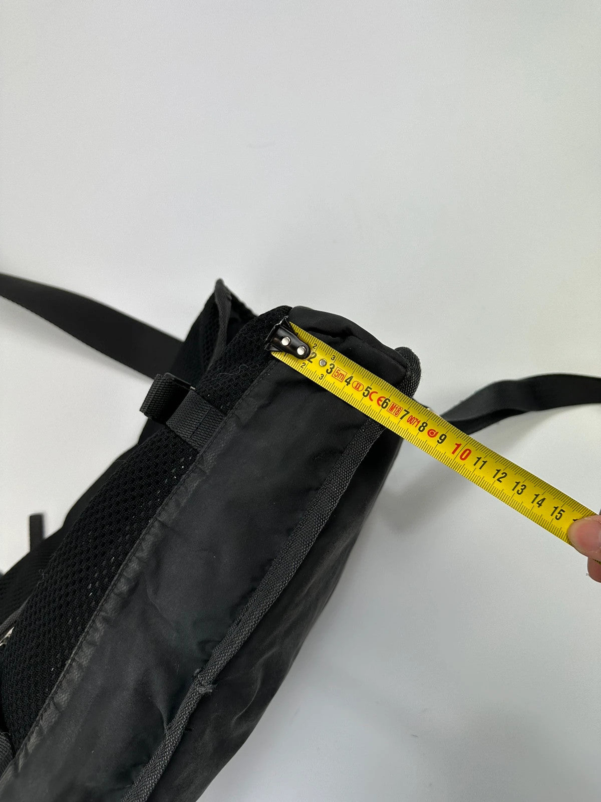Prada black and grey mesh crossbody waist bag with logo and dual compartment design.