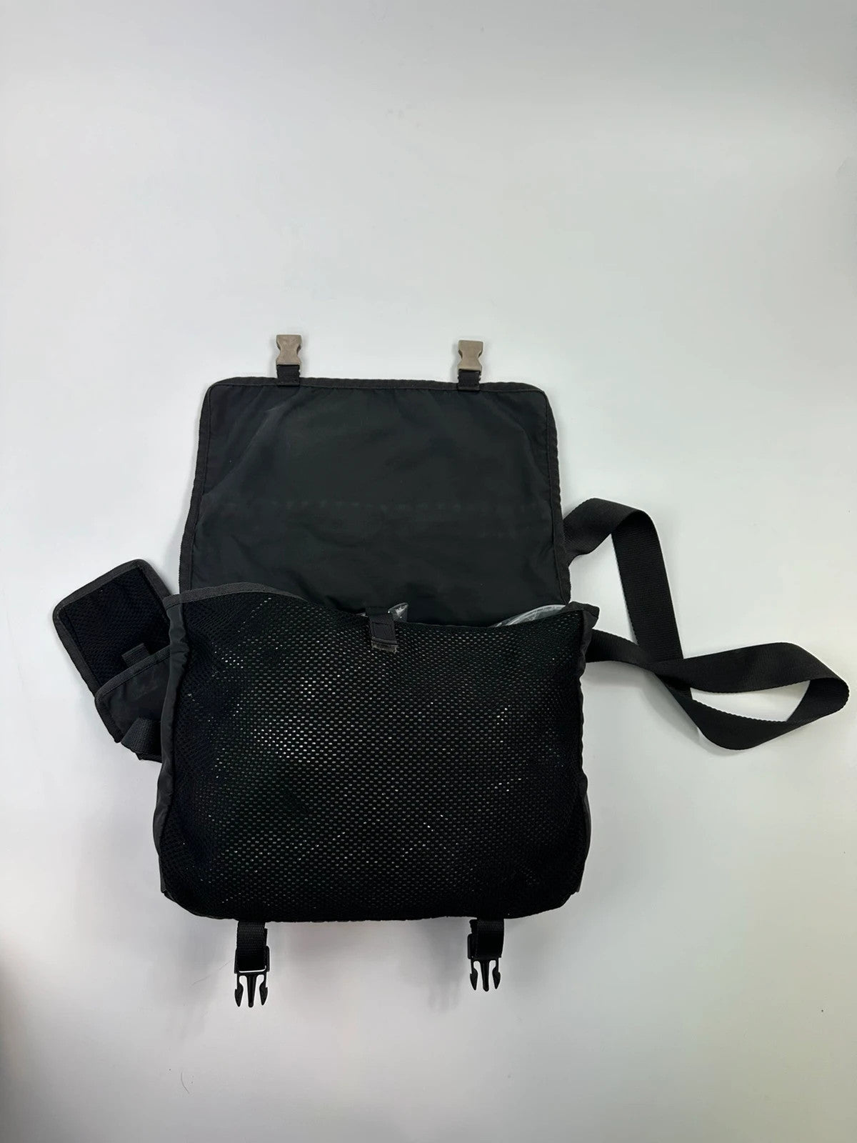 Prada black and grey mesh crossbody waist bag with logo and dual compartment design.