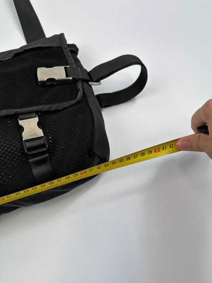 Prada black and grey mesh crossbody waist bag with logo and dual compartment design.