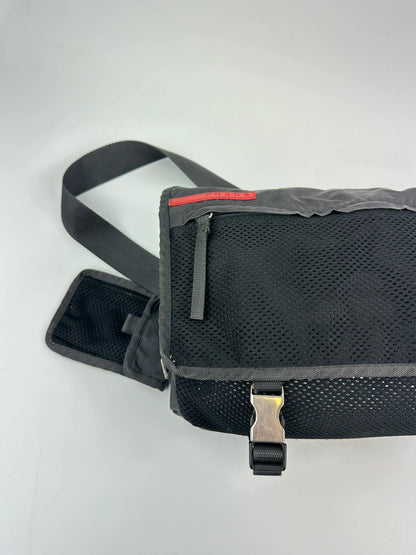Prada black and grey mesh crossbody waist bag with logo and dual compartment design.