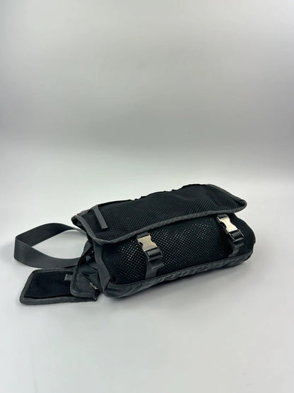 Prada black and grey mesh crossbody waist bag with logo and dual compartment design.