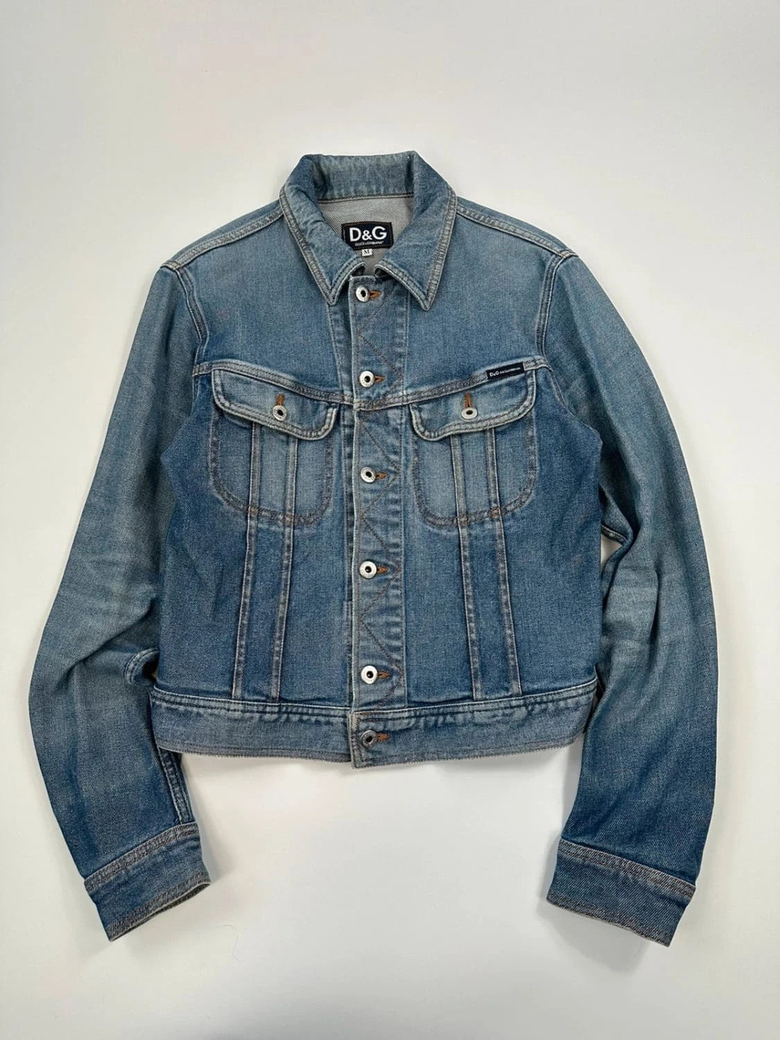 Dolce & Gabbana blue boxy crop denim jacket with logo detail and distressed finish.