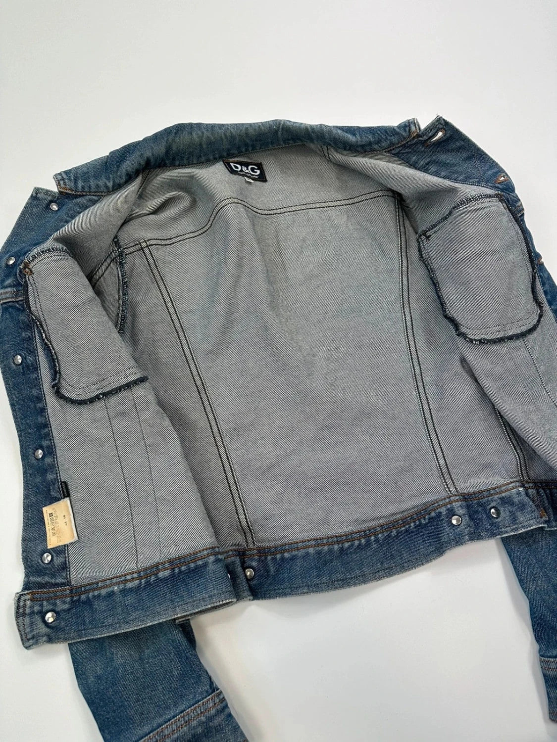 Dolce & Gabbana blue boxy crop denim jacket with logo detail and distressed finish.