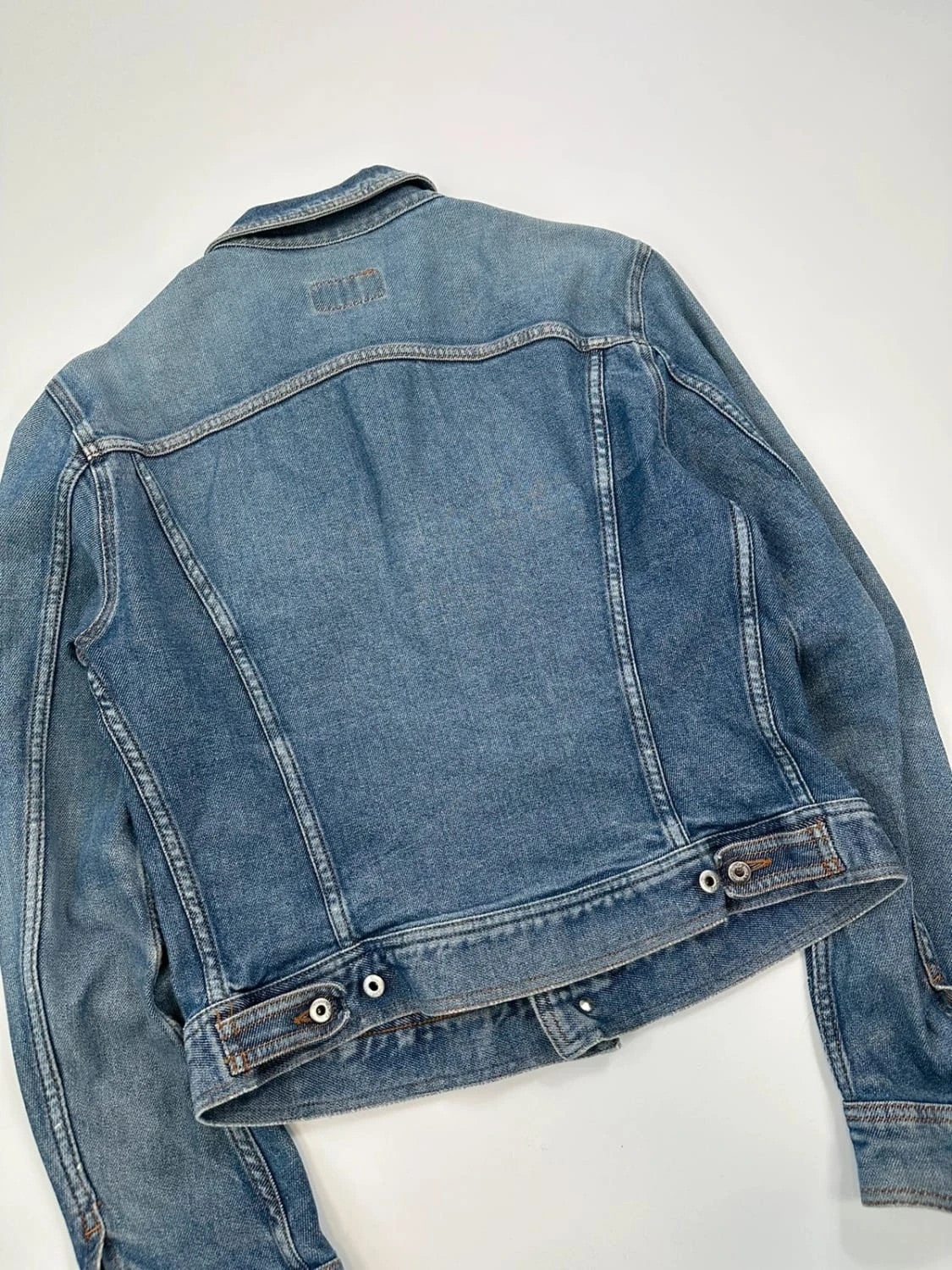 Dolce & Gabbana blue boxy crop denim jacket with logo detail and distressed finish.