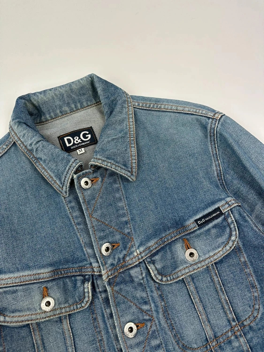 Dolce & Gabbana blue boxy crop denim jacket with logo detail and distressed finish.