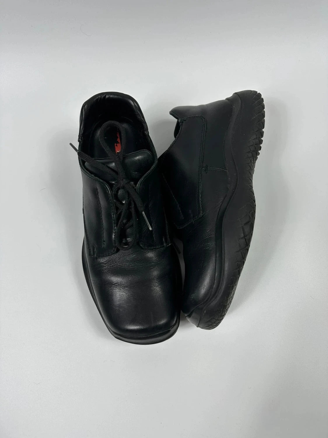Prada black leather loafer with Vibram sole, sleek futuristic design from FW1999 collection.