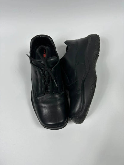 Prada black leather loafer with Vibram sole, sleek futuristic design from FW1999 collection.