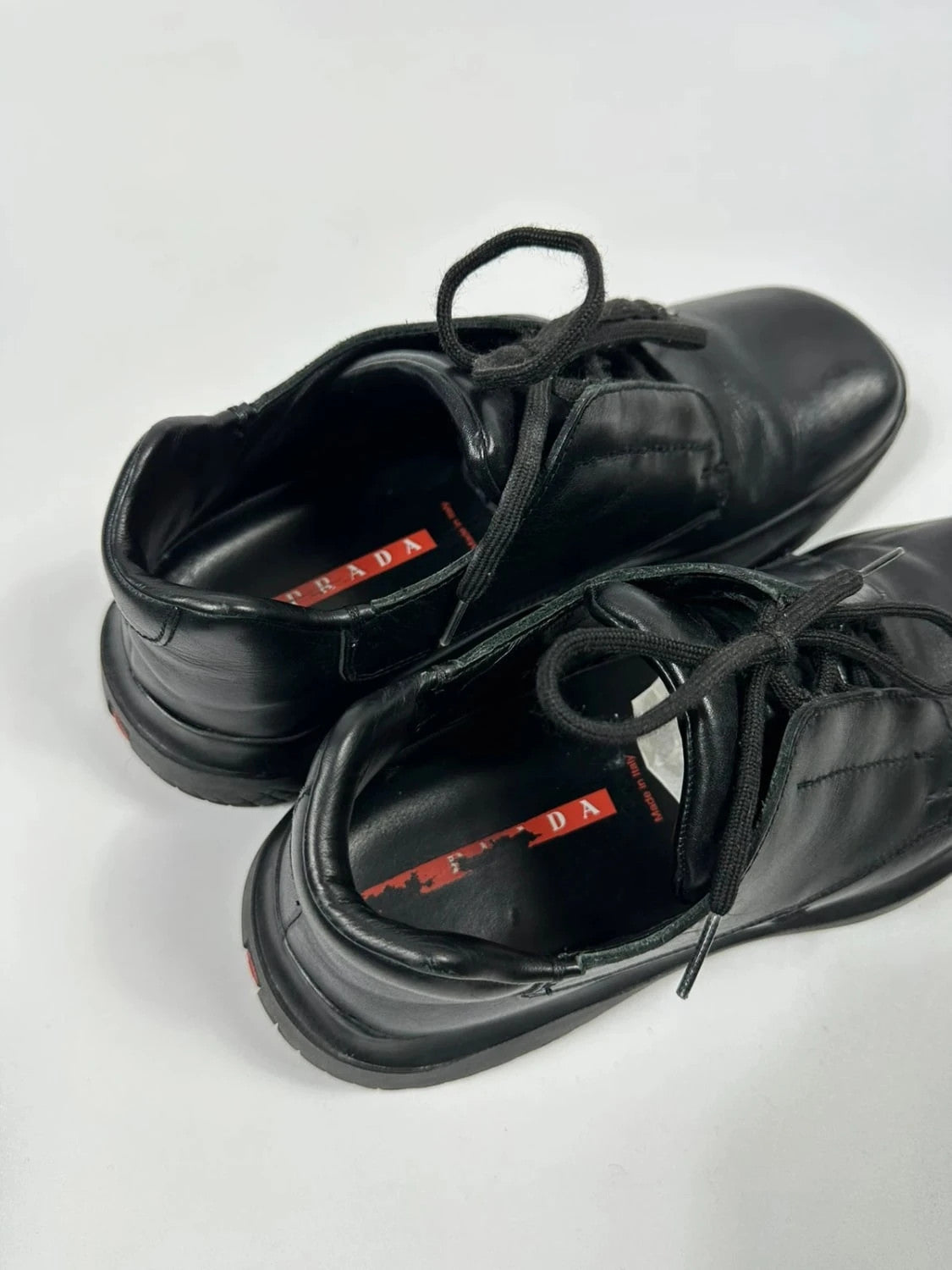 Prada black leather loafer with Vibram sole, sleek futuristic design from FW1999 collection.