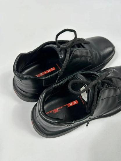 Prada black leather loafer with Vibram sole, sleek futuristic design from FW1999 collection.