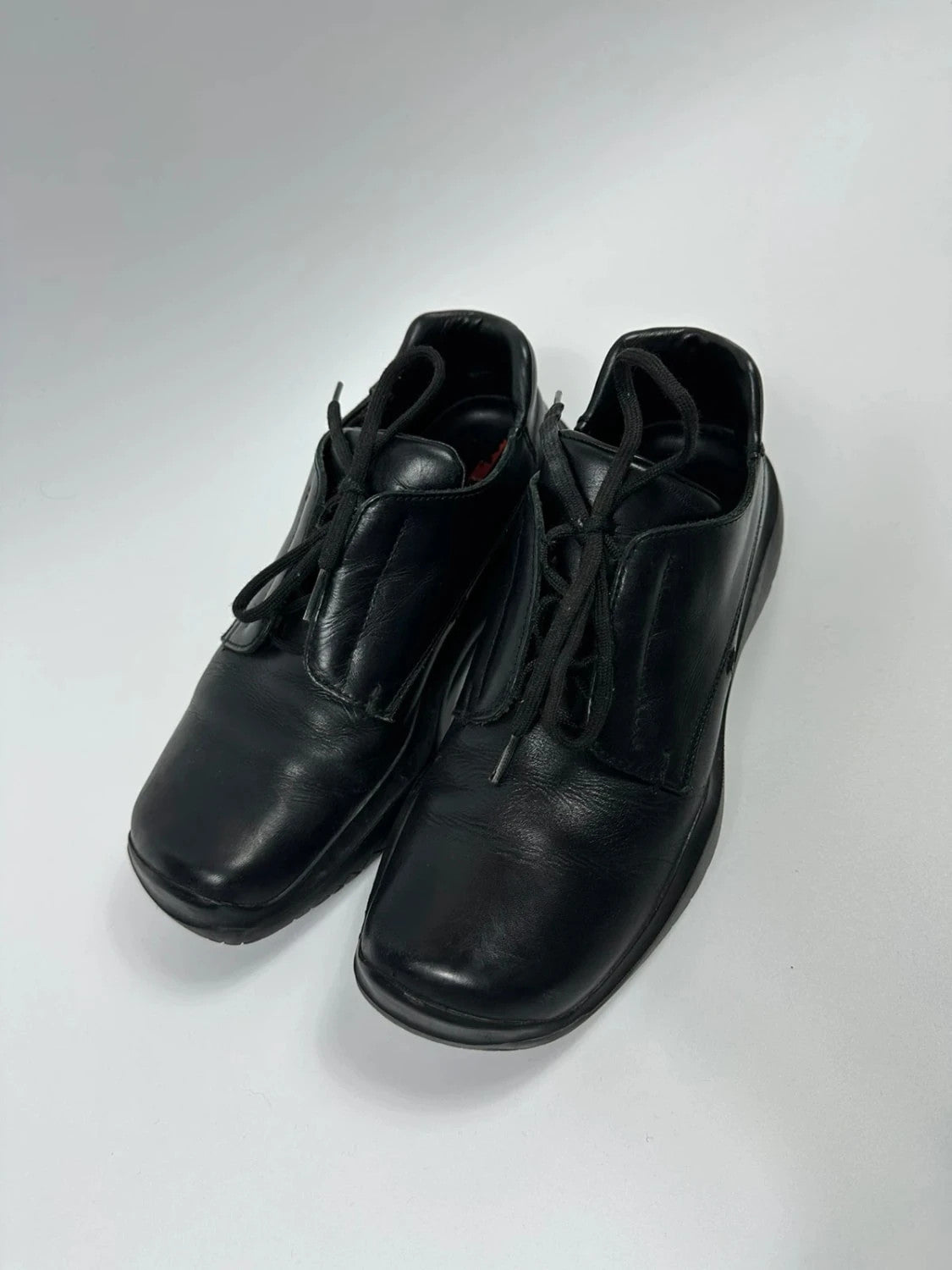 Prada black leather loafer with Vibram sole, sleek futuristic design from FW1999 collection.