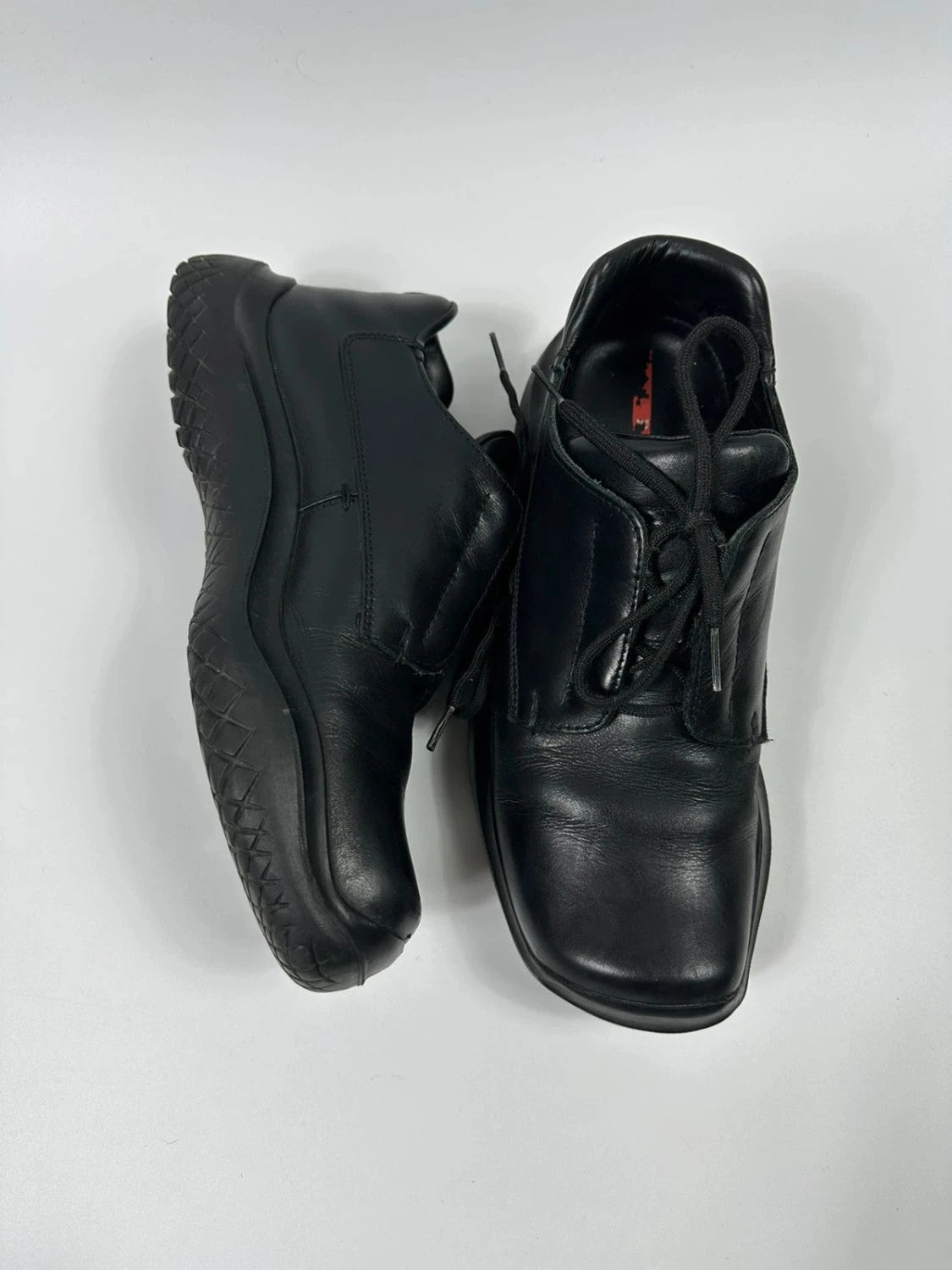 Prada black leather loafer with Vibram sole, sleek futuristic design from FW1999 collection.