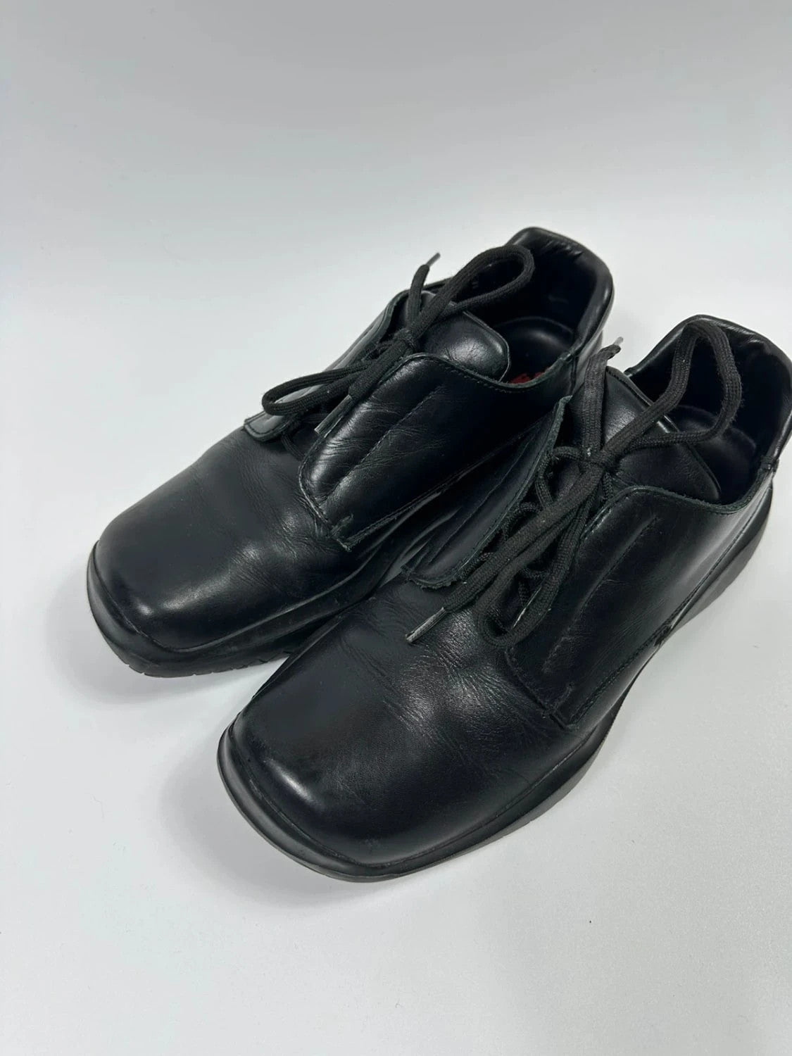 Prada black leather loafer with Vibram sole, sleek futuristic design from FW1999 collection.