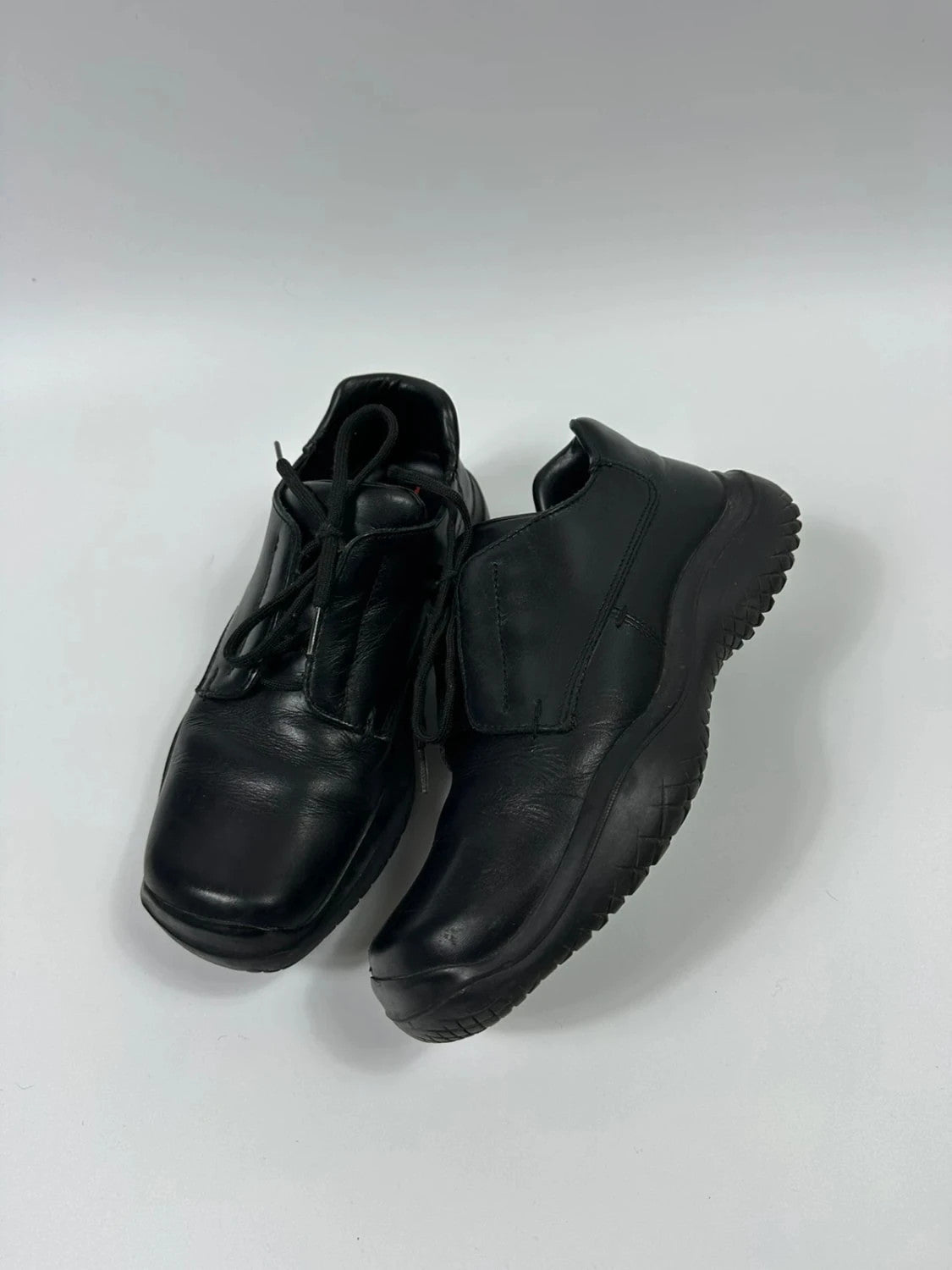 Prada black leather loafer with Vibram sole, sleek futuristic design from FW1999 collection.