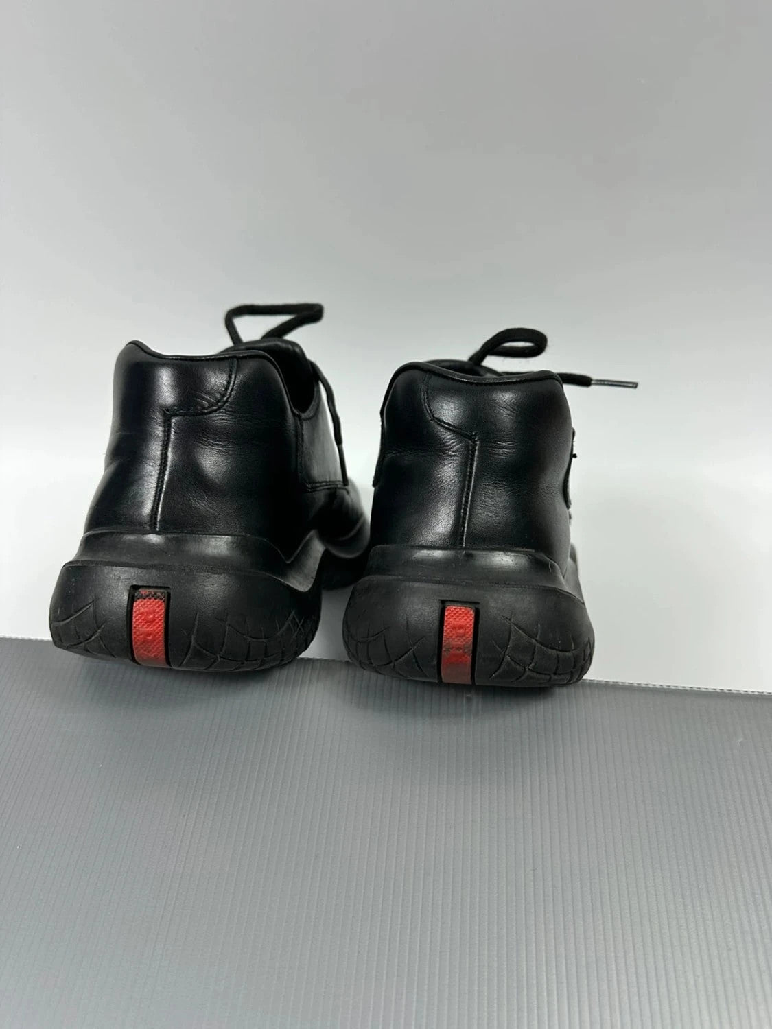 Prada black leather loafer with Vibram sole, sleek futuristic design from FW1999 collection.