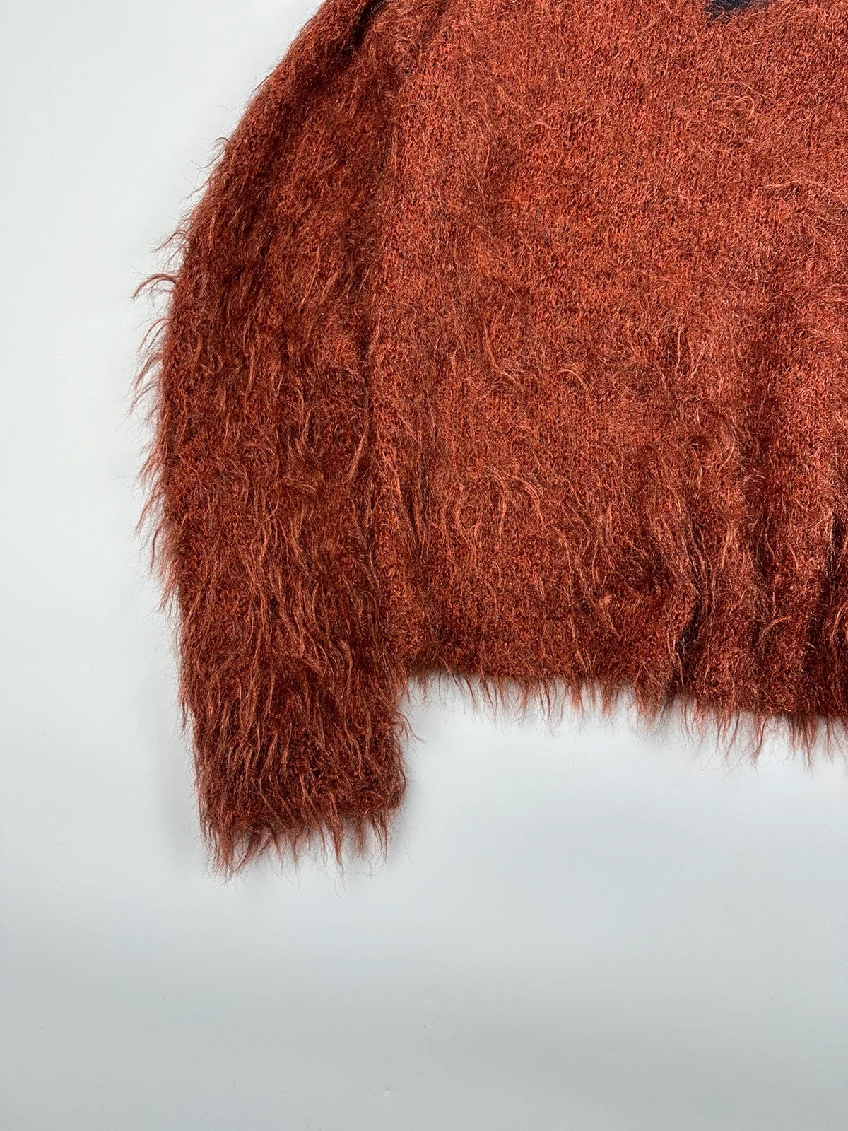Acne Studios oversized cropped sweater in red and orange hairy knit texture.