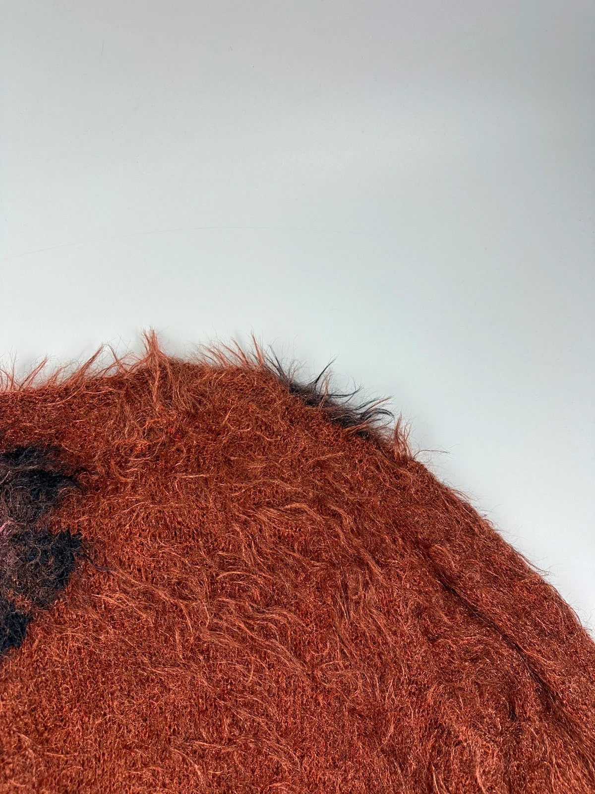 Acne Studios oversized cropped sweater in red and orange hairy knit texture.