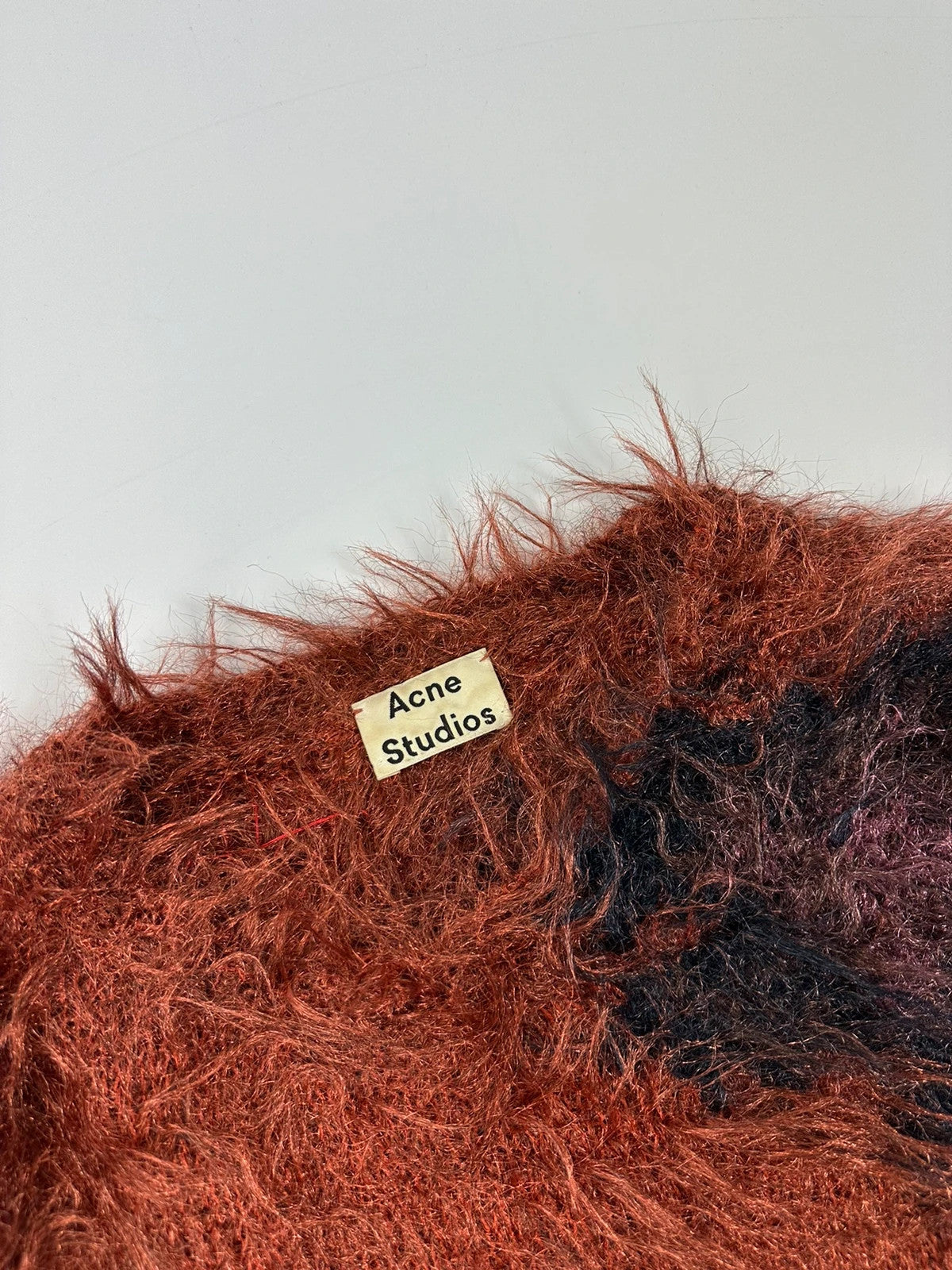 Acne Studios oversized cropped sweater in red and orange hairy knit texture.
