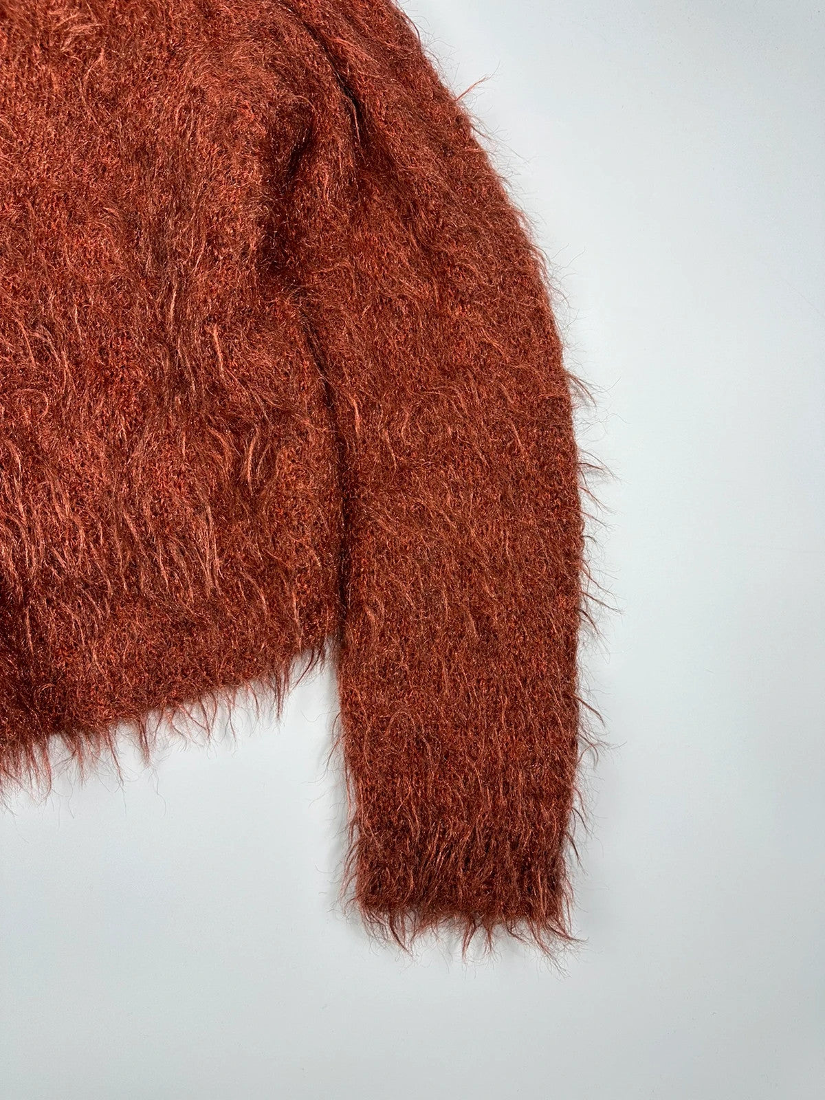Acne Studios oversized cropped sweater in red and orange hairy knit texture.
